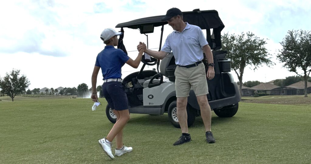 HJGT junior golfer with coach