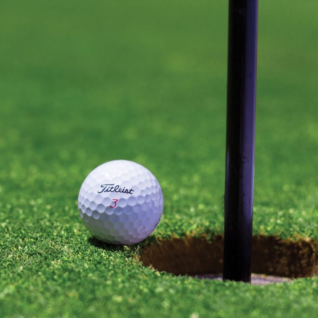 a golf ball about to go into the hole